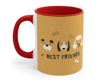 May include: A ceramic mug with a bright red handle and interior rim. The exterior features a tan background with black and white illustrations of three dog faces, two bone shapes, and the text BEST FRIENDS printed in a bold, dark font.