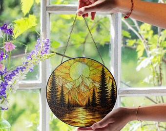 Atrapasueños de vidrieras con paisaje de montaña dorada, bosque alpino y picos al atardecer, decoración para ventanas inspirada en la naturaleza.