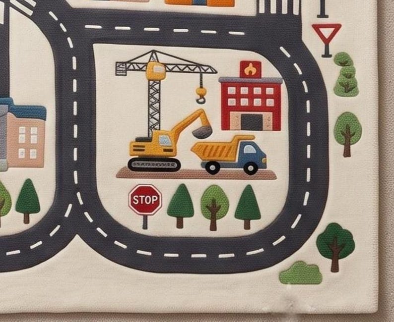 May include: A cream-colored play mat featuring a printed city map with dark gray roads, a yellow construction crane, a yellow excavator, a blue dump truck, a red fire station, green trees, and a red octagonal stop sign with white text.