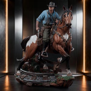 May include: A detailed statue of a cowboy on horseback. The cowboy wears a blue shirt, hat, and holds a gun. The horse is brown and white. The base features a miniature railroad track and a "Wanted" sign.