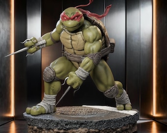 May include: A detailed statue of Raphael from Teenage Mutant Ninja Turtles. The figure is green with a red mask, holding two sai. The statue is posed on a sewer-themed base, showcasing intricate details and textures.