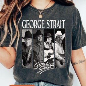 May include: Dark gray t-shirt featuring a black and white image of George Strait in four panels. The text "GEORGE STRAIT" is printed above the image, with "George Strait" in cursive below. A classic country music tee.