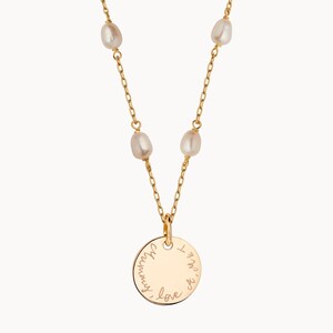 May include: Gold necklace with a round pendant that says "I love you always". The necklace has five small white pearls.