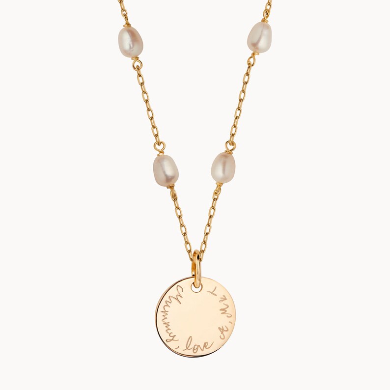 May include: Gold necklace with a round pendant that says "I love you always". The necklace has five small white pearls.