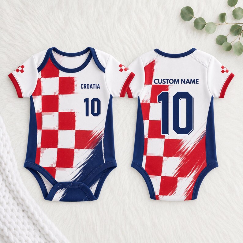May include: Two baby bodysuits featuring a red and white chequered pattern, navy blue trim, and short sleeves. The front displays the text CROATIA and the number 10. The back displays the text CUSTOM NAME and the number 10 in navy blue font.