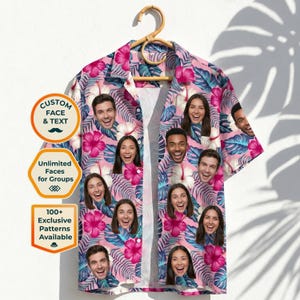 May include: A short-sleeved button-down shirt with a pink floral pattern and faces of people. The shirt is hanging on a wooden hanger. The shirt has a tropical design with pink hibiscus flowers and blue leaves. The shirt has the text "Custom Face & Text", "Unlimited Faces for Groups", and "100+ Exclusive Patterns Available".