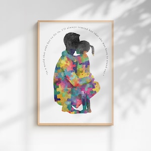 Könnte beinhalten: Ein gerahmter Kunstdruck mit der Silhouette eines Erwachsenen und eines Kindes in einer Umarmung, gefüllt mit einem bunten Aquarell-Puzzle-Muster. Der Text um die Figuren lautet, In a world that asks her to fit in, I'll always remind her that she was born to stand out.