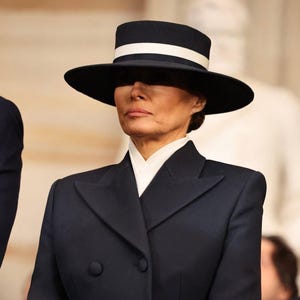 Könnte beinhalten: Ein marineblauer Hut mit breiter Krempe und weißem Band. Der Hut wird mit einem passenden marineblauen, zweireihigen Blazer und einem weißen Hemd mit Kragen getragen. Das Outfit ist ein klassischer und eleganter Stil.