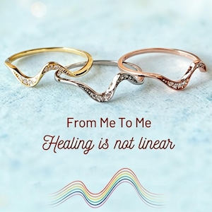 May include: Three wavy rings in yellow gold, silver, and rose gold tones, each featuring small embedded stones. The text "From Me To Me" and "Healing is not linear" appears above a colorful, multi-line wave graphic at the bottom of the image.