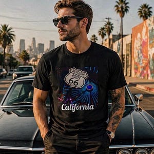 Könnte beinhalten: Schwarzes T-Shirt mit einem Aufdruck des Historic Route 66-Schildes, einem farbenfrohen Design und dem Wort "California". Das T-Shirt wird von einer Person mit Sonnenbrille getragen.
