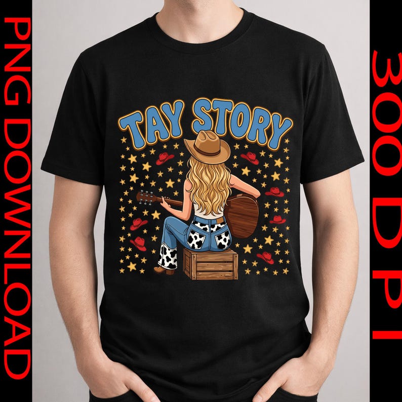 Pu&ograve; includere: Una t-shirt nera con la grafica di una persona bionda che indossa un cappello da cowboy, jeans blu con macchie di mucca e suona una chitarra acustica seduta su una cassa di legno. Il testo TAY STORY appare sopra con stelle gialle.