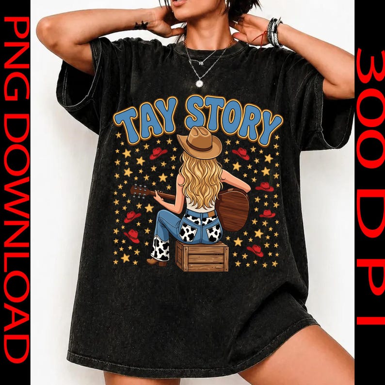 Pu&ograve; includere: Una t-shirt nera con lavaggio minerale che presenta la grafica di una persona bionda con cappello da cowboy seduta su una cassa di legno mentre suona la chitarra. Il testo TAY STORY appare in blu sopra la figura, circondato da stelle gialle e cappelli rossi.