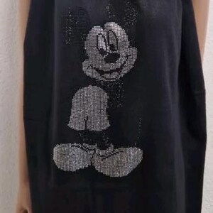 Könnte beinhalten: Schwarzer Schal mit einem glitzernden Mickey Mouse-Motiv. Der Schal hat eine rechteckige Form mit einem Fransenbesatz. Das Mickey Mouse-Design besteht aus kleinen, glänzenden Verzierungen.