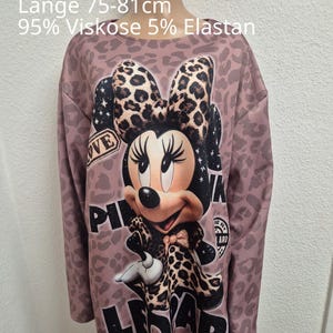 Könnte beinhalten: Ein langärmeliges Oberteil mit altrosa Leopardenmuster und einem Minnie-Maus-Motiv mit passender Schleife. Der Text auf dem Kleidungsstück lautet 'Einheitsgröße 50-54', 'Achsel 75cm', 'Länge 75-81cm', '95% Viskose 5% Elastan' und 'LEOPARD'.