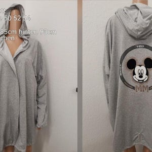 Può includere: Felpa con cappuccio grigia con grafica di Mickey Mouse sul retro. La felpa ha una lunghezza anteriore di 85 cm e una lunghezza posteriore di 93 cm. Ha tasche laterali ed è realizzata in Italia.