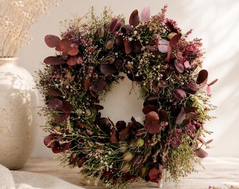 Ghirlanda estiva e ghirlanda autunnale con eucalipto appena tinto, lavanda di mare rosa-rossa, nigella e gypsophila rosa.