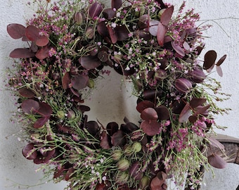 Ghirlanda estiva e ghirlanda autunnale con eucalipto appena tinto, lavanda di mare rosa-rossa, nigella e gypsophila rosa.