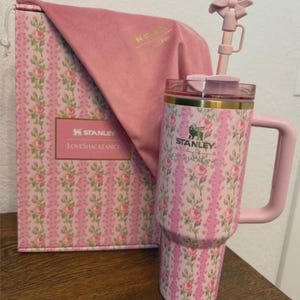 Puede incluir: Un vaso Stanley y LoveShackFancy rosa con estampado floral, asa rosa a juego, tapa transparente y pajita con un lazo rosa. El vaso viene acompa&ntilde;ado de una bolsa de tela rosa y una caja que presenta el mismo dise&ntilde;o floral en su exterior.