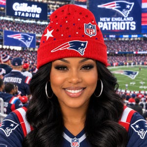 May include: A bright red knit beanie featuring the New England Patriots logo, a white star, and scattered red, white, and blue rhinestones. The hat includes a small NFL shield patch on the front and has a folded cuff design with a ribbed texture.