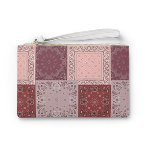 Könnte beinhalten: Eine rechteckige Clutch mit einem Patchwork-Design aus verschiedenen Bandana-Mustern in Altrosa, Mauve und tiefem Burgunderrot. Die Tasche verfügt über eine weiße Handschlaufe, die an einem goldfarbenen Reißverschluss an der Oberkante befestigt ist.