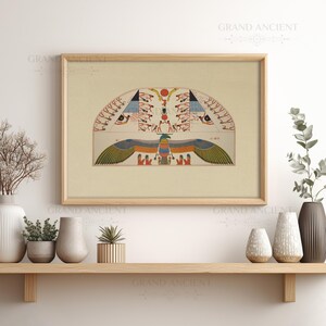 May include: A framed wall art print featuring an ancient Egyptian illustration with a central winged deity, a scarab beetle, and multiple figures in red, blue, green, and gold tones, set against a light beige background within a wooden frame.