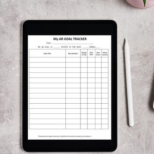 May include: A black tablet displaying a "My AR GOAL TRACKER" form. The form includes fields for book title, quiz number, test date, and points earned. A white stylus and a small potted plant are next to the tablet.