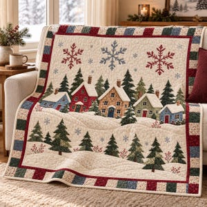 May include: A quilted throw blanket featuring a winter village scene with snow-covered houses, evergreen trees, and red and blue snowflakes on a cream background. The border consists of a patchwork pattern in red, green, and blue fabric squares.
