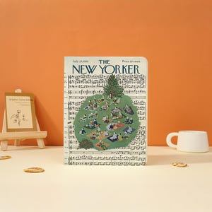 Puede incluir: Una portada de revista rectangular titulada The New Yorker, fechada el 23 de julio de 1955, con un precio de 20 centavos. La portada presenta un fondo de notación musical con una ilustración central verde de personas haciendo un picnic bajo un pino.