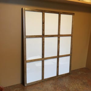 May include: A wooden picture frame with nine square openings. The frame is brown and has a rustic finish. The openings are empty.