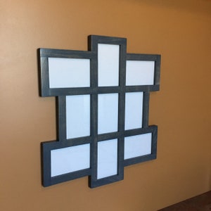 May include: A dark gray wooden picture frame with nine openings for photos. The frame is arranged in a grid pattern and has a distressed finish.