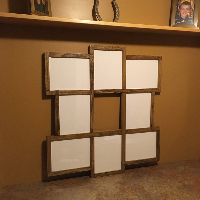 May include: A rustic wooden picture frame with nine openings, arranged in a grid pattern. The frame is made of dark brown wood with a distressed finish.