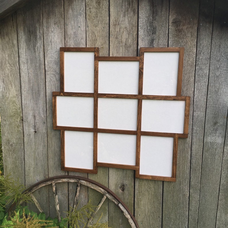 May include: A wooden picture frame with nine openings, each with a white background. The frame is stained a dark brown color and has a rustic appearance.