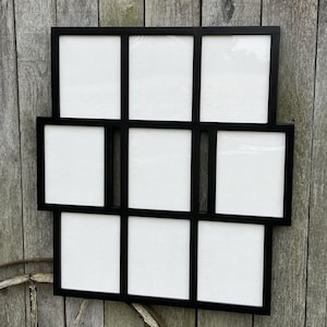 May include: Black picture frame with nine openings for photos. The frame is made of wood and has a simple, modern design.