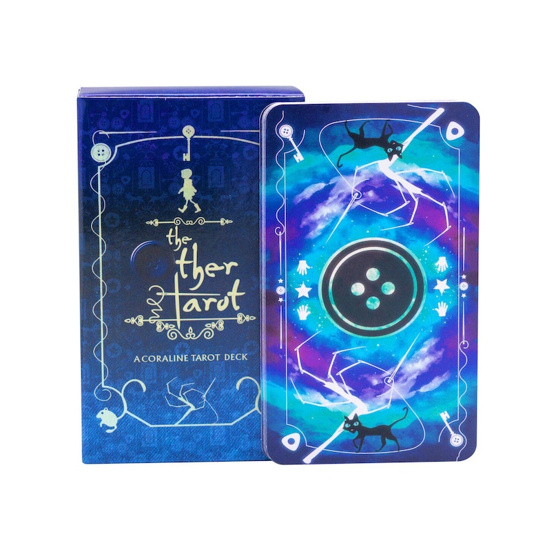 Puede incluir: Una baraja de tarot de Coraline que incluye una caja azul con el texto The Other Tarot y una carta a juego que muestra un bot&oacute;n negro grande, siluetas de gatos negros y patrones de telara&ntilde;a blancos sobre un fondo de nebulosa azul y morada.