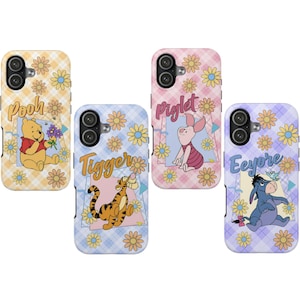 May include: Four rectangular phone cases featuring Winnie the Pooh, Tigger, Piglet, and Eeyore. Each case has a plaid background with yellow flower patterns and the character's name printed in a cursive font above their respective illustrations.