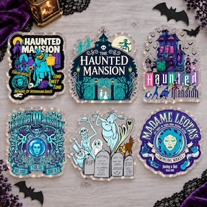 May include: Six acrylic Haunted Mansion themed decorative plaques featuring colorful illustrations of ghosts, tombstones, and mansion architecture. Each piece displays text including The Haunted Mansion, Madame Leota, and various spooky phrases.