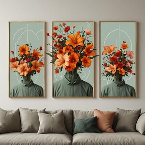 Peut inclure: Un triptyque d'art mural représentant trois silhouettes vêtues de chemises à col vert sauge. Chaque personnage a un bouquet éclatant de lys et de coquelicots orange et rouges en guise de tête, sur un fond vert pâle avec des lignes blanches.
