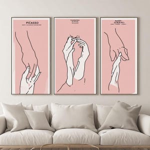 Peut inclure: Un ensemble de trois affiches murales verticales présentant des dessins au trait noir de mains sur un fond rose pâle. Chaque affiche montre des gestes de mains différents et inclut un petit texte noir en haut, dont Picasso à gauche.