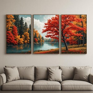 Peut inclure: Un ensemble de trois tableaux muraux représentant un paysage forestier en automne. La scène montre un lac calme entouré d'arbres aux feuillages rouge, orange et jaune vifs sous un ciel nuageux, le tout encadré par de fines bordures en bois sombre.