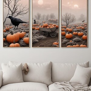 Puede incluir: Un conjunto de arte mural tríptico con tres paneles verticales que representan una escena de un campo de calabazas con niebla. La imagen incluye calabazas naranjas, un cuervo negro, un carro de madera y árboles desnudos bajo un cielo pálido.