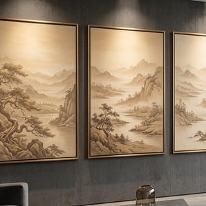 May include: A set of three vertical rectangular wall art pieces in thin gold frames, each featuring a monochromatic sepia-toned landscape painting of misty mountains, winding rivers, and gnarled pine trees on a textured dark gray wall.