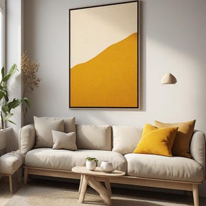 Peut inclure: Une œuvre d'art murale rectangulaire présentant un design divisé avec une section supérieure crème et une section inférieure jaune moutarde texturée, encadrée d'un fin cadre noir, au-dessus d'un canapé beige avec des coussins assortis et jaunes.