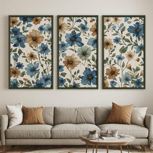 Peut inclure: Un ensemble de trois tableaux muraux rectangulaires verticaux présentant un motif floral répétitif avec des fleurs bleues et fauves, des feuilles et des tiges vertes sur un fond crème, chacun encadré par un fin cadre vert foncé.