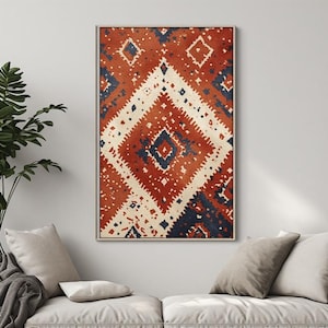 Peut inclure: Une impression d'art murale rectangulaire présentant un grand motif en losange central dans des tons orange brûlé, crème et bleu marine foncé. Le design comprend de plus petits motifs géométriques et des bords dentelés, sous cadre.