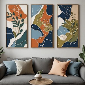 Peut inclure: Un ensemble de trois tableaux muraux rectangulaires présentant des formes abstraites superposées dans des tons orange brûlé, bleu marine profond, vert olive et crème. Les motifs intègrent des feuilles botaniques et un coquillage blanc.