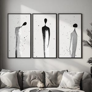 Peut inclure: Un ensemble de trois impressions murales verticales dans des cadres noirs, chacune représentant une silhouette humaine abstraite et stylisée en noir et blanc avec un effet texturé et moucheté sur un fond blanc, disposées côte à côte.