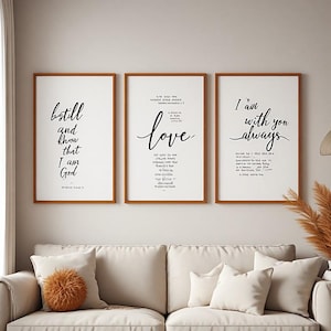 Peut inclure: Trois cadres muraux verticaux avec des bordures marron. L'affiche de gauche porte l'inscription "be still and know that I am God". Celle du centre affiche le mot "love" en écriture cursive. Celle de droite indique "I am with you always".
