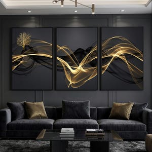 Peut inclure: Trois tableaux abstraits encadrés. Chacun présente un fond noir avec des lignes dorées et noires fluides. Le panneau de gauche comporte une silhouette d'arbre dorée. L'œuvre est exposée au-dessus d'un canapé gris foncé avec des coussins.