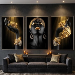 May include: A triptych wall art set featuring three vertical panels with black and gold imagery. The outer panels display dark-toned hands adorned with stacked gold bracelets, while the center panel depicts a face with gold makeup and jewelry.