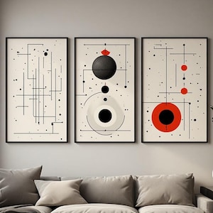 Peut inclure: Un ensemble de trois impressions d'art mural rectangulaires dans des cadres noirs. Les impressions présentent des fonds blanc cassé avec des lignes, des points et des formes géométriques noirs, dont un grand cercle rouge et des accents rouges.